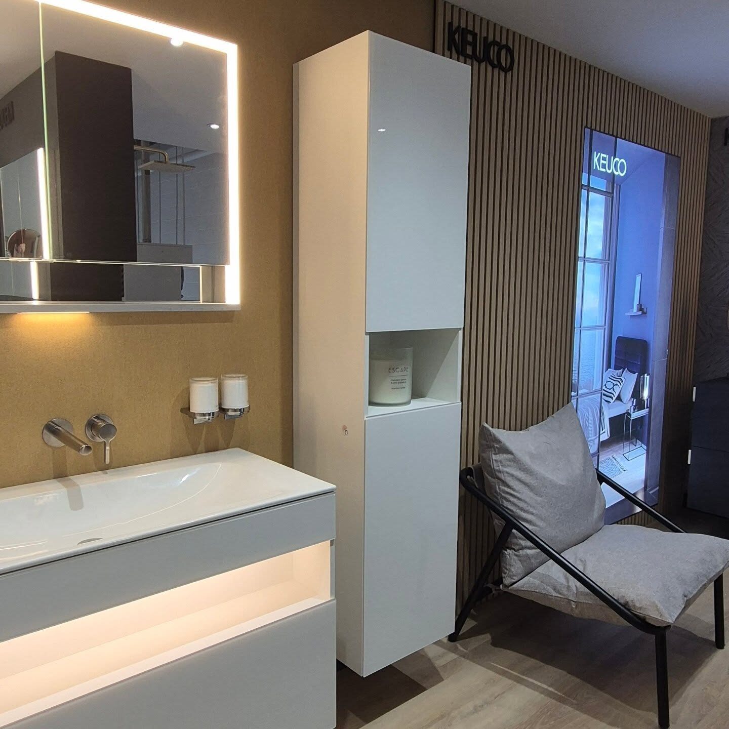 White vanity with illuminated mirror cabinet and tall storage unit