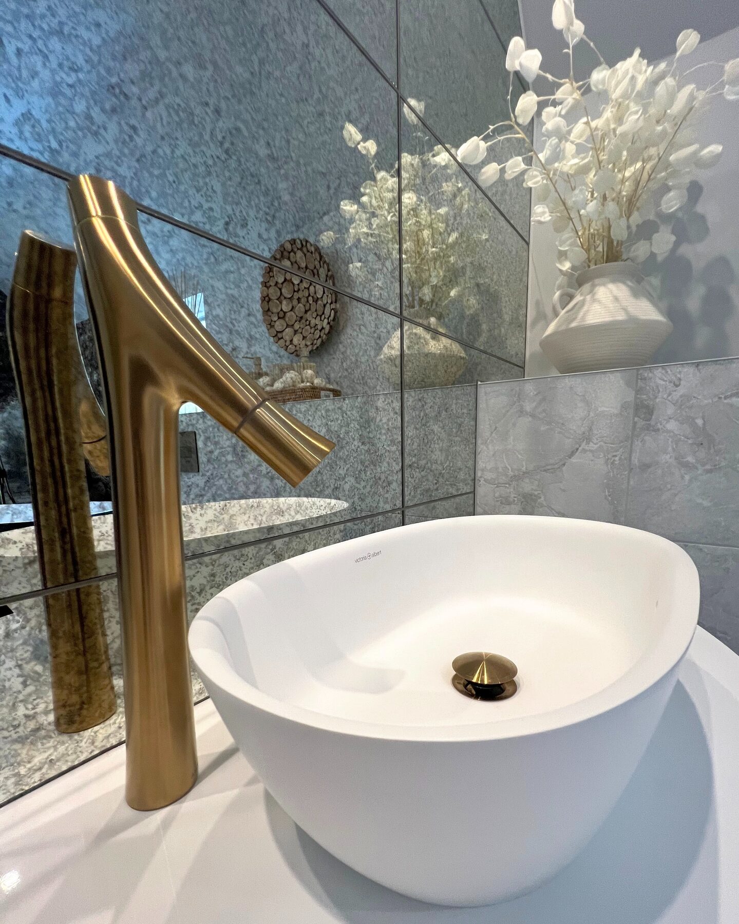 Brass basin tap beside a white countertop basin